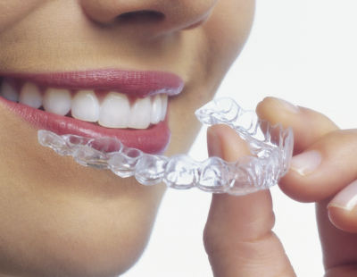 Closeup of woman placing Invisalign tray