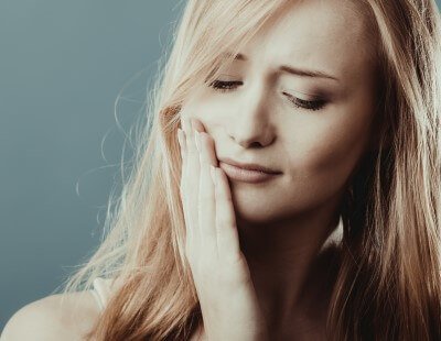 Man in pain holding cheek