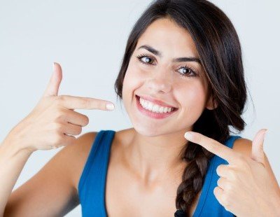 Woman pointing to her beautiful smile